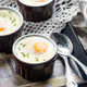 shirred eggs on table with spoons